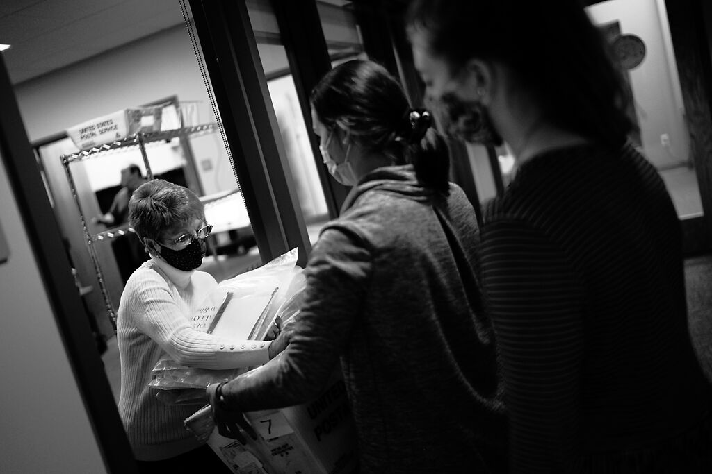 Beverly Braun takes a box of election material from Rebecca Jennings and Kristen Ross near the end of election night